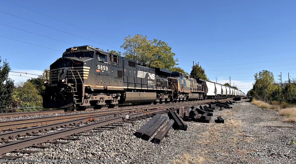 NS 9859 leads an empty sand hopper train west,